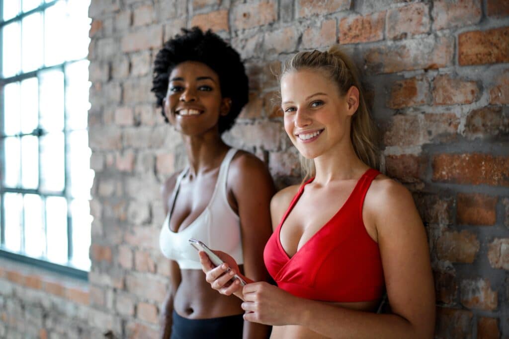 Warum werden die Brüste der britischen Frauen immer größer? 2 Woman in Red Sports Bra Beside Woman in White Sports Bra